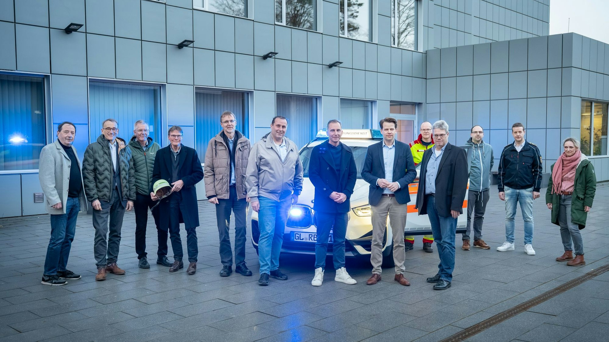 Das LNA-Team mit Arne von Boetticher, dem stellvertretenden Dezernatsleiter Thomas Mönig, Amtsleiter Thomas Hagen und dem Ärztlichen Leiter Rettungsdienst, Florian Breuer steht am Kreishaus vor einem Rettungsdienstwagen.