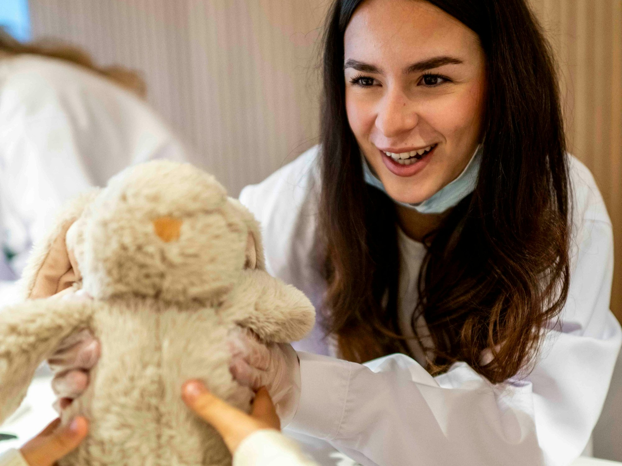 Das Bild zeigt eine Mitarbeiterin der AOK, die sich um ein verletztes Kuscheltier kümmert.