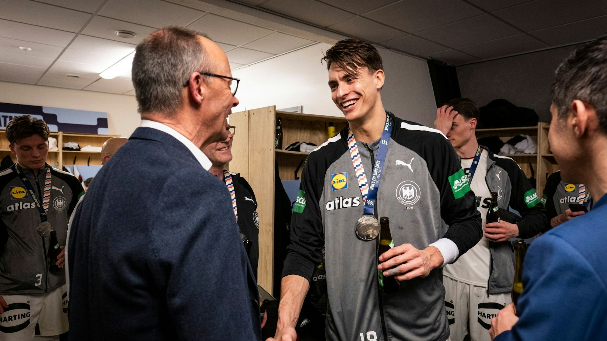 Bundeskanzler Friedrich Merz gratuliert Deutschlands Handballern in der Kabine.