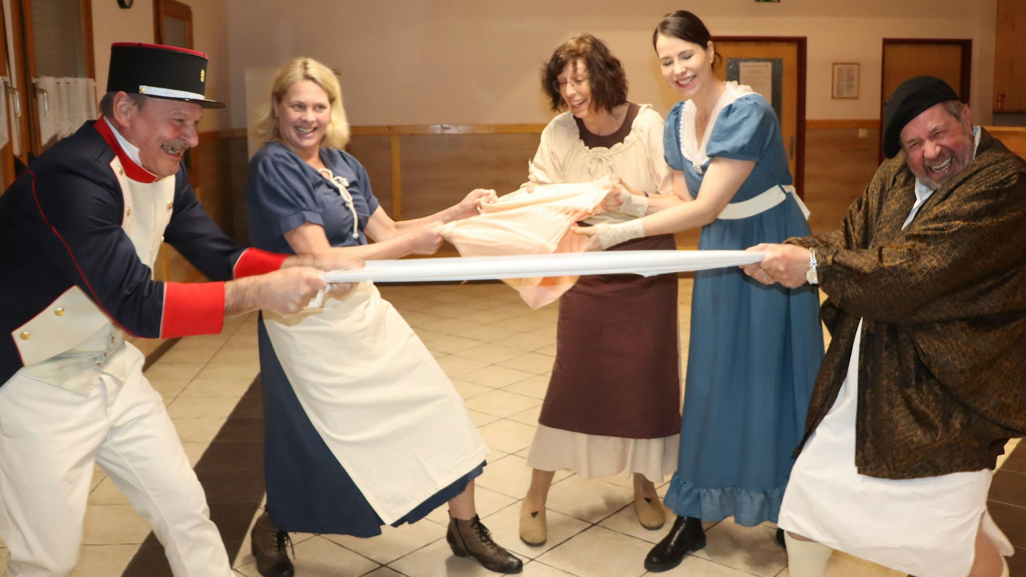 Schauspieler in Kostümen des frühen 19. Jahrhunderts ziehen lange Unterhosen oder Hüfthalter - wie früher üblich beim Wäschewaschen.