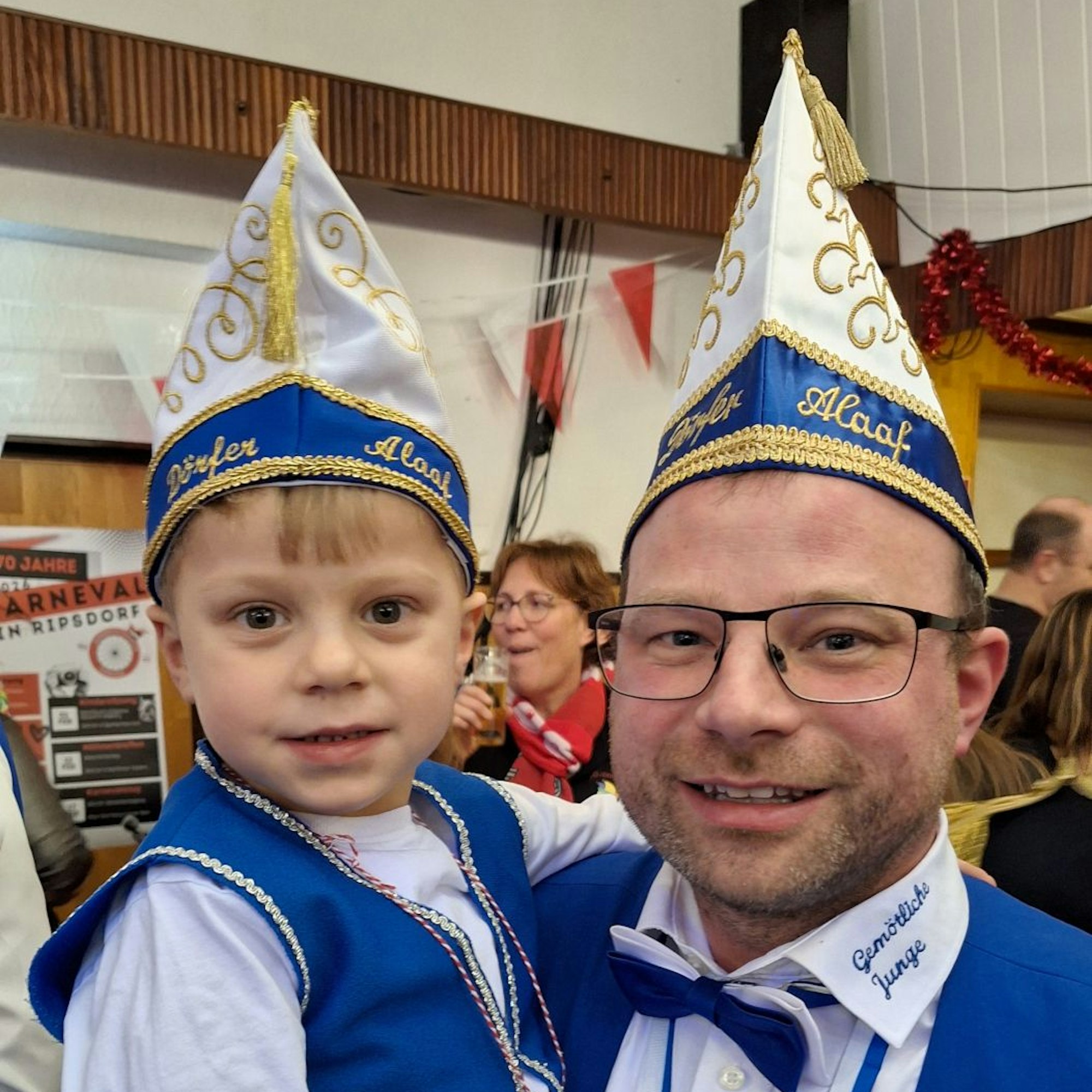 Ein Vater hat hält seinen vierjährigen Sohn - beide sind verkleidet.