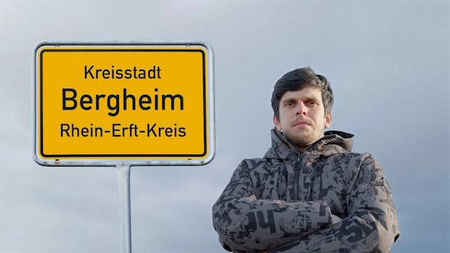 Auf dem Foto steht ein Mann mit verschränkten Armen vor einem Ortsschild der Stadt Bergheim.