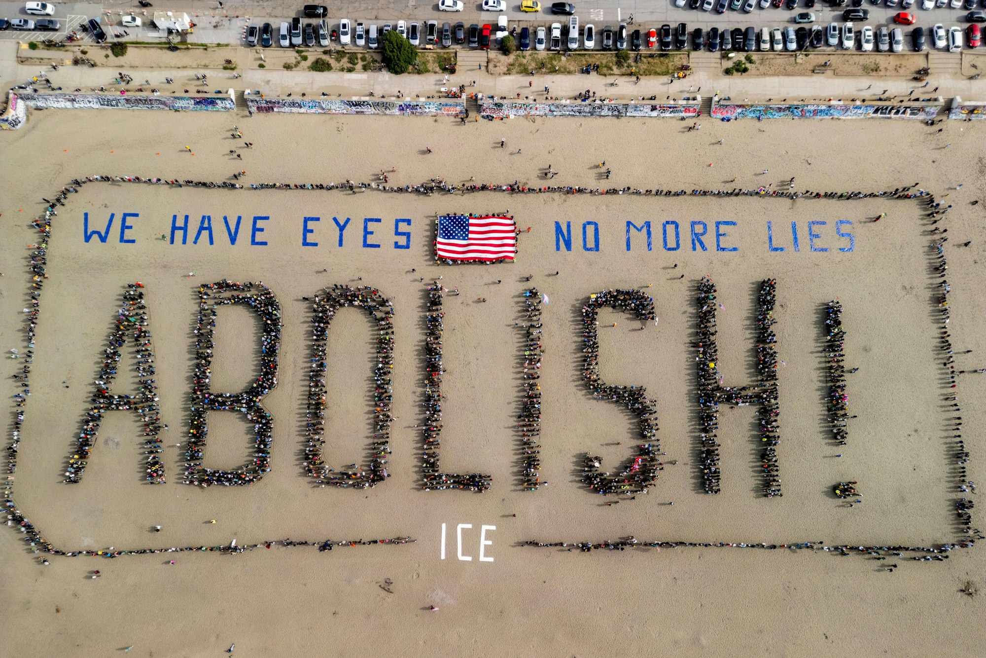 San Francisco: Für einer Luftaufnahme bilden Demonstranten ein menschliches Banner „We have eyes - no more lies - Abolish“ am Ocean Beach während eines Protests gegen landesweite Razzien gegen Einwanderer und damit verbundene Unruhen in Minneapolis.