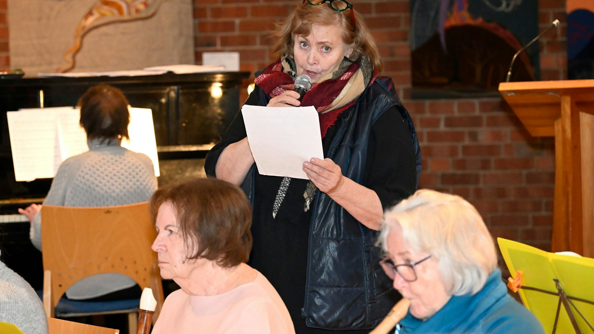 Die Sängerin hält ein Mikrofon in der Hand.