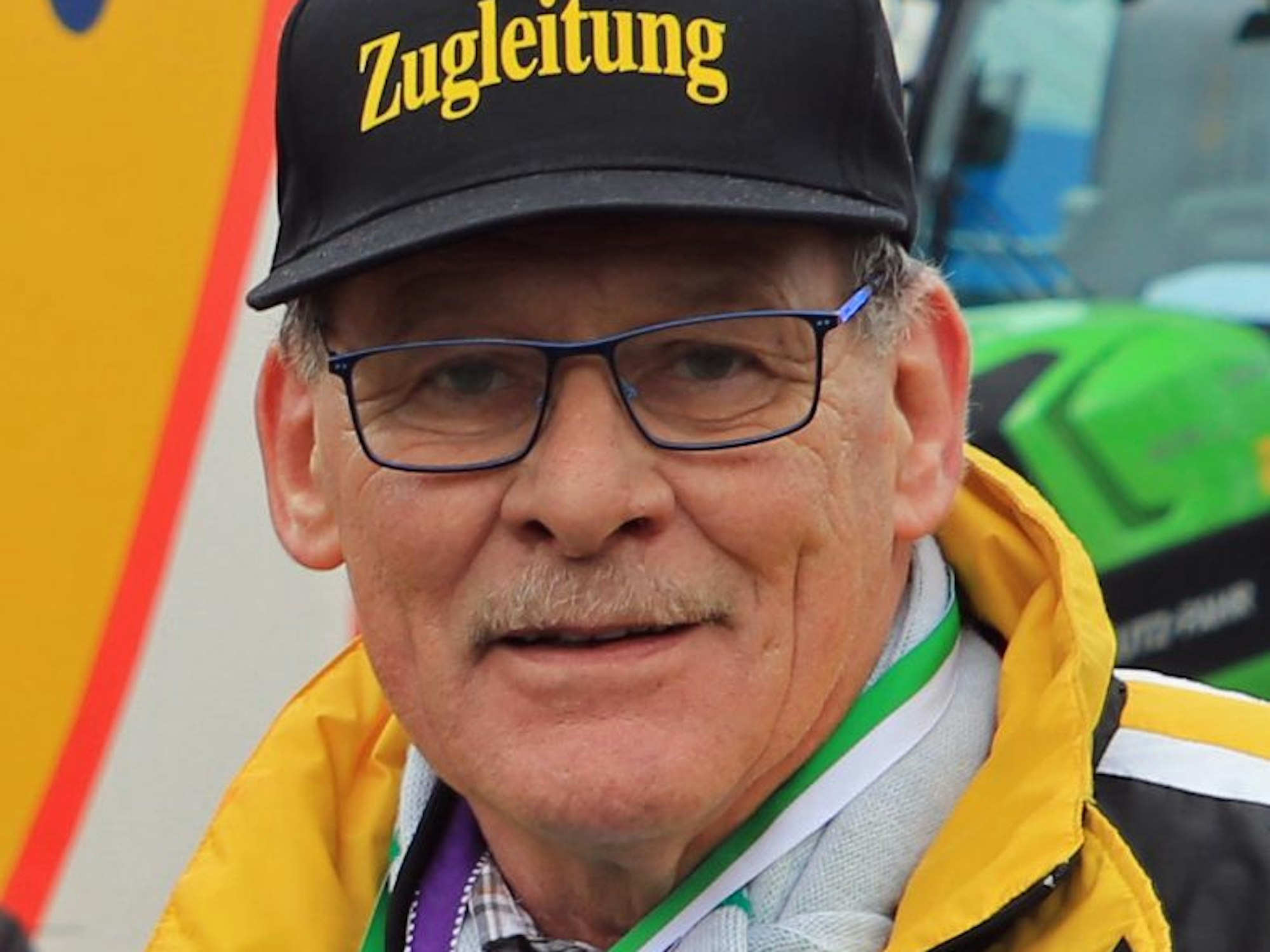 Auf dem Bild ist das Portrait eines Mannes mit Brille und Kappe zu sehen.