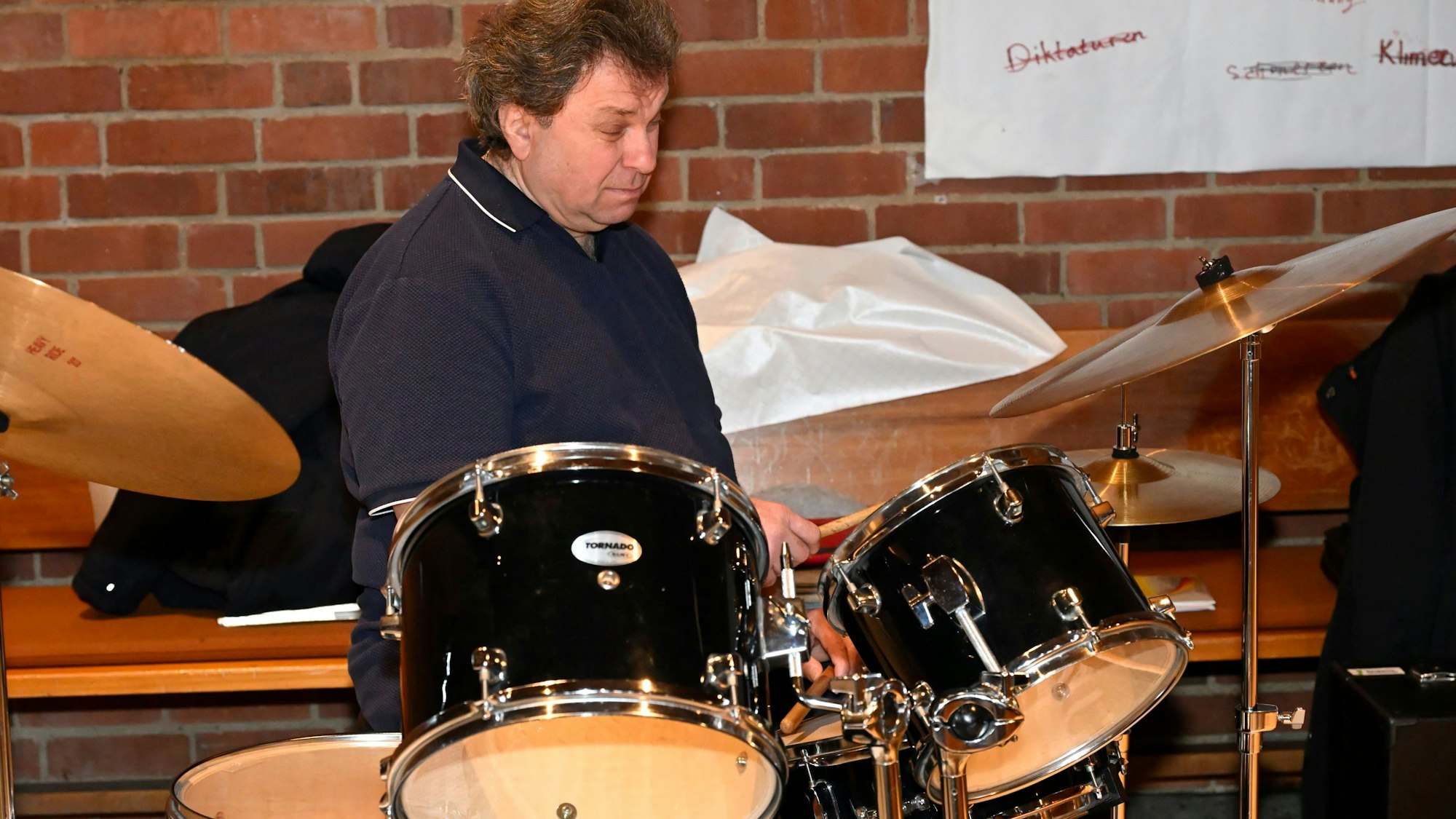 Der Schlagzeuger sitzt vor seinem Instrument.