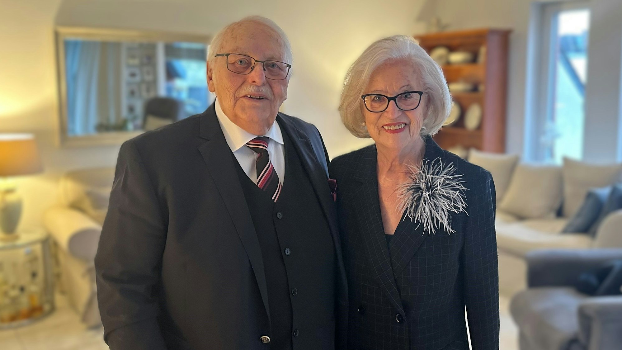 Ein Ehepaar steht in seinem Wohnzimmer.