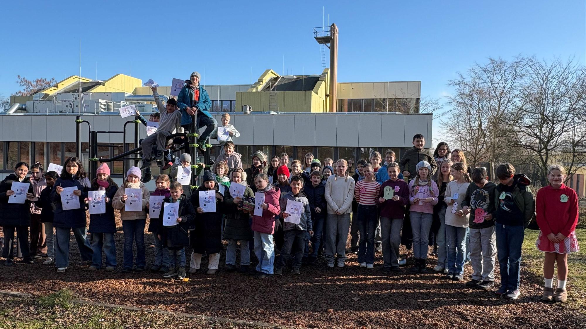 Zum Abschluss machen die Dritt- und Sechstklässler ein gemeinsames Gruppenfoto. Die Grundschüler präsentieren ihre Urkunden.