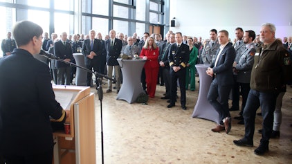 Flottillenadmiral Sabine Reppin ist von hinten am Rednerpult zu sehen. Sie blickt auf die 130 Gäste des Neujahresempfangs.