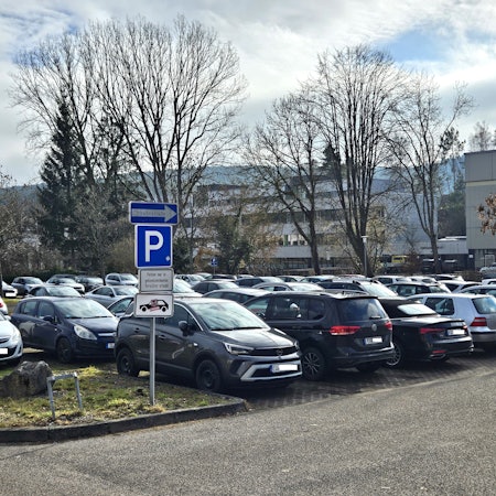 Blick auf den vollen Parkplatz an der Aachener Straße. Im Hintergrund ist das Berufskolleg zu sehen.