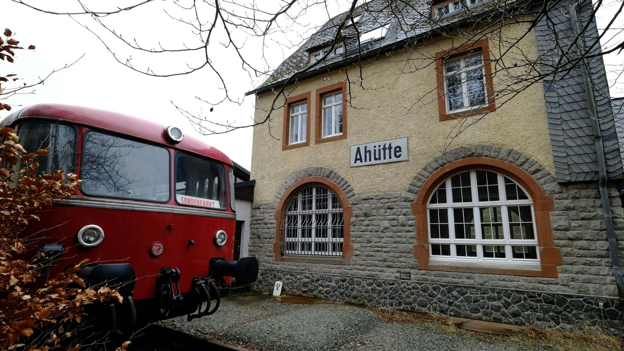 Museumsbahnhof Ahütte: Außenansicht mit rotem Schienenbus.