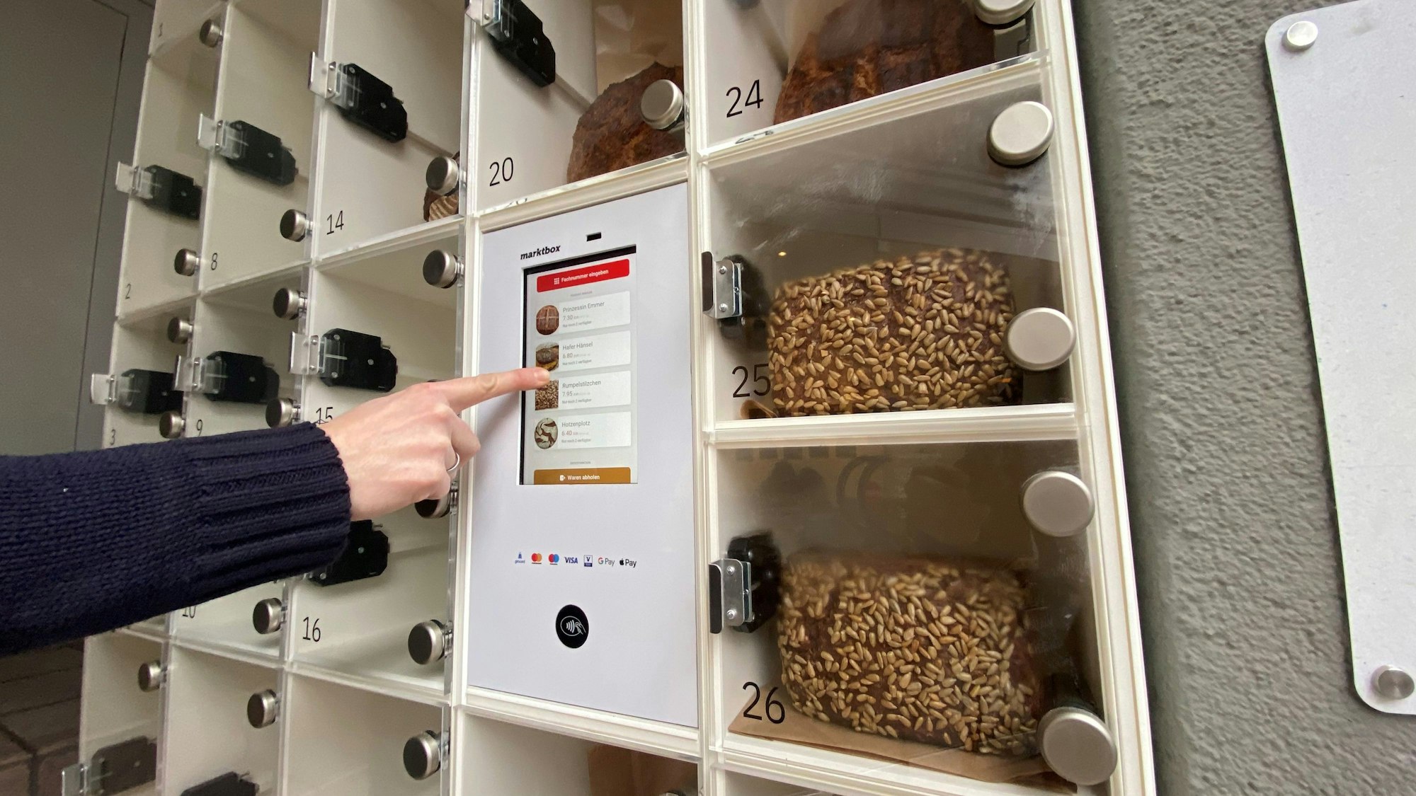 Zu sehen ist der Brot-Automat, in dessen Fächern Brotlaibe liegen.