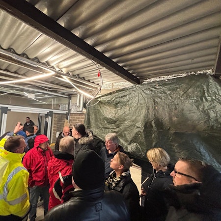 Auf dem Bild ist eine Personengruppe zu sehen, die eine Baustelle besichtigt.