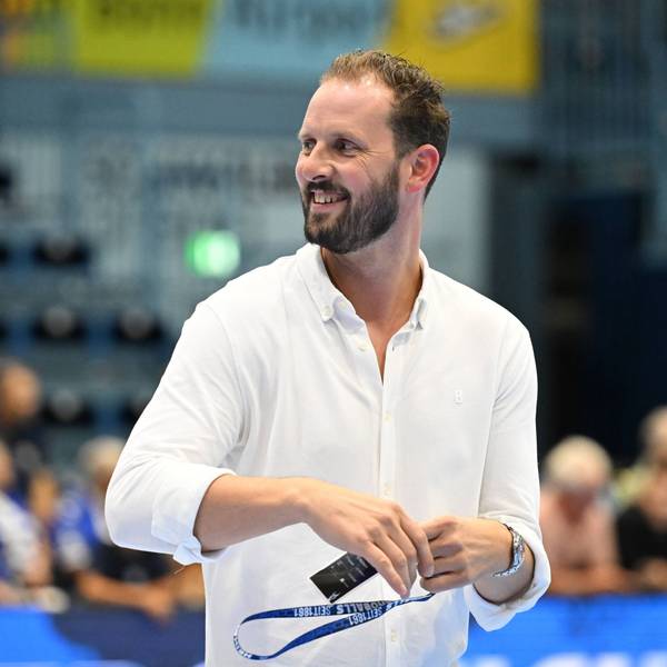 Christoph Schindler geht lachend über das Spielfeld in der Schwalbe-Arena.