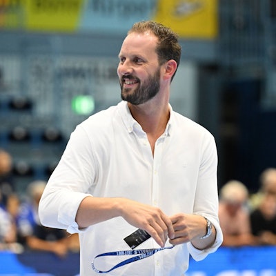 Christoph Schindler geht lachend über das Spielfeld in der Schwalbe-Arena.