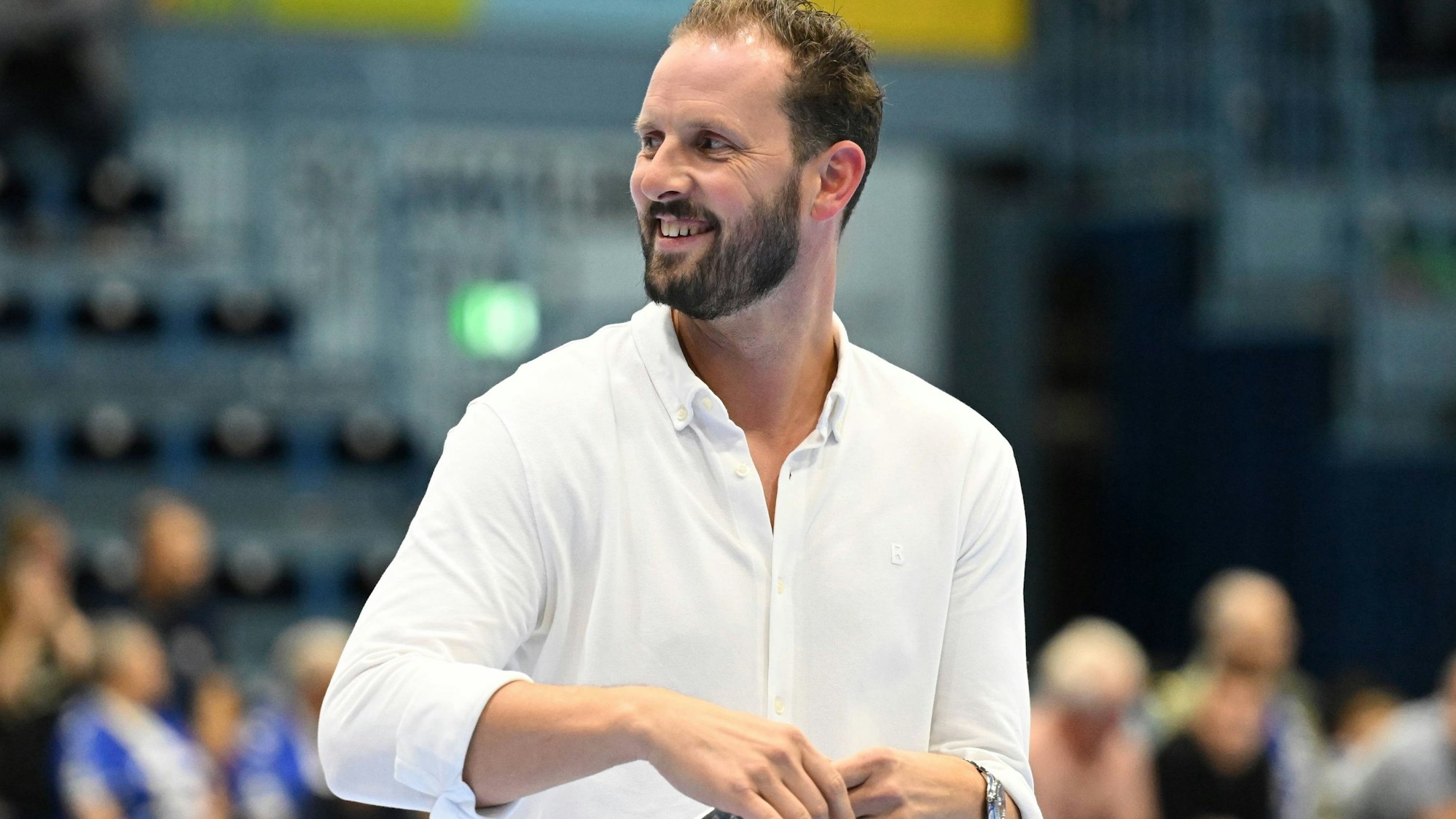 Christoph Schindler geht lachend über das Spielfeld in der Schwalbe-Arena.
