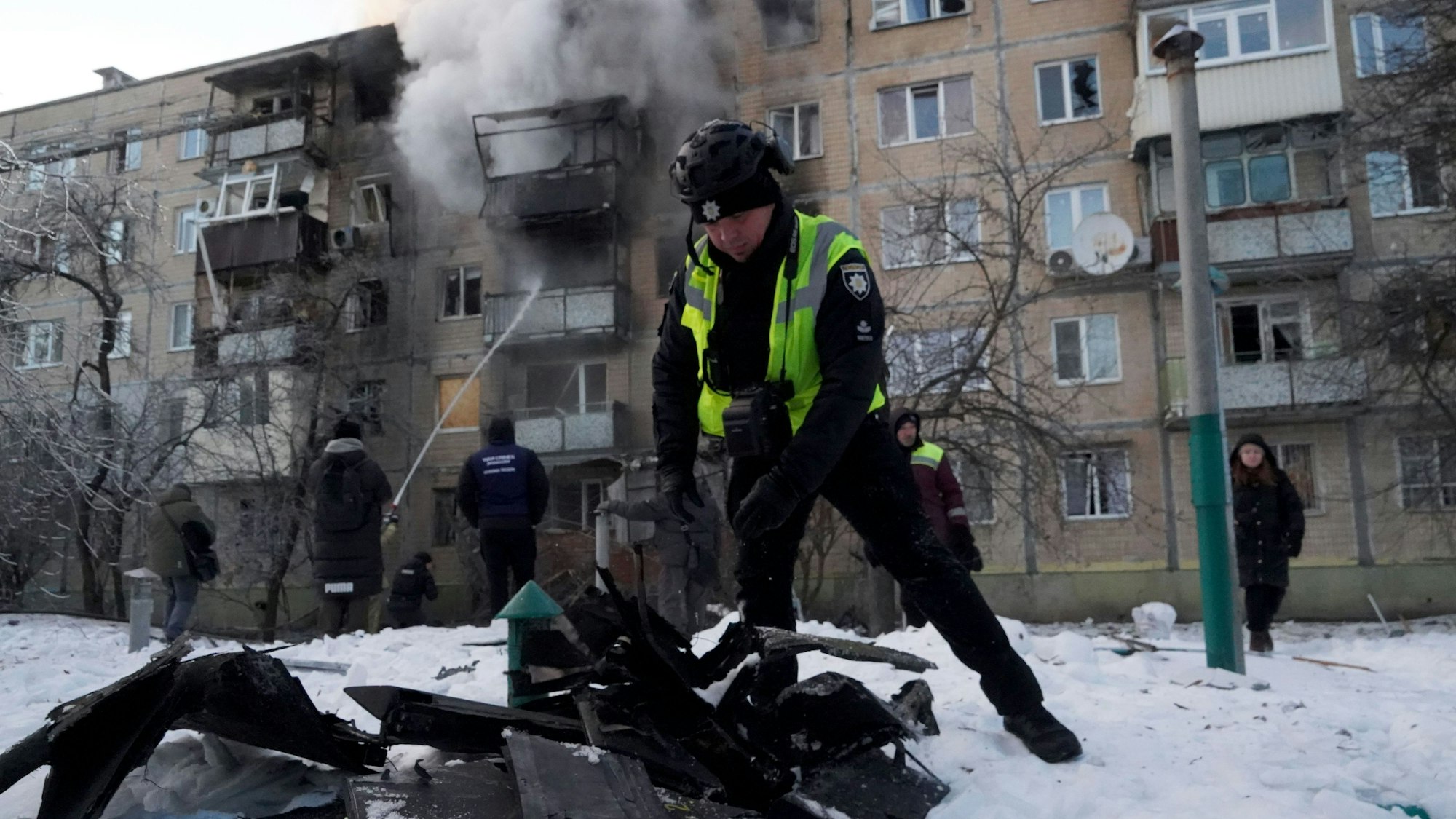 Ein Polizist untersucht in Charkiw Fragmente einer russischen Drohne, die ein Wohnhaus getroffen hat.