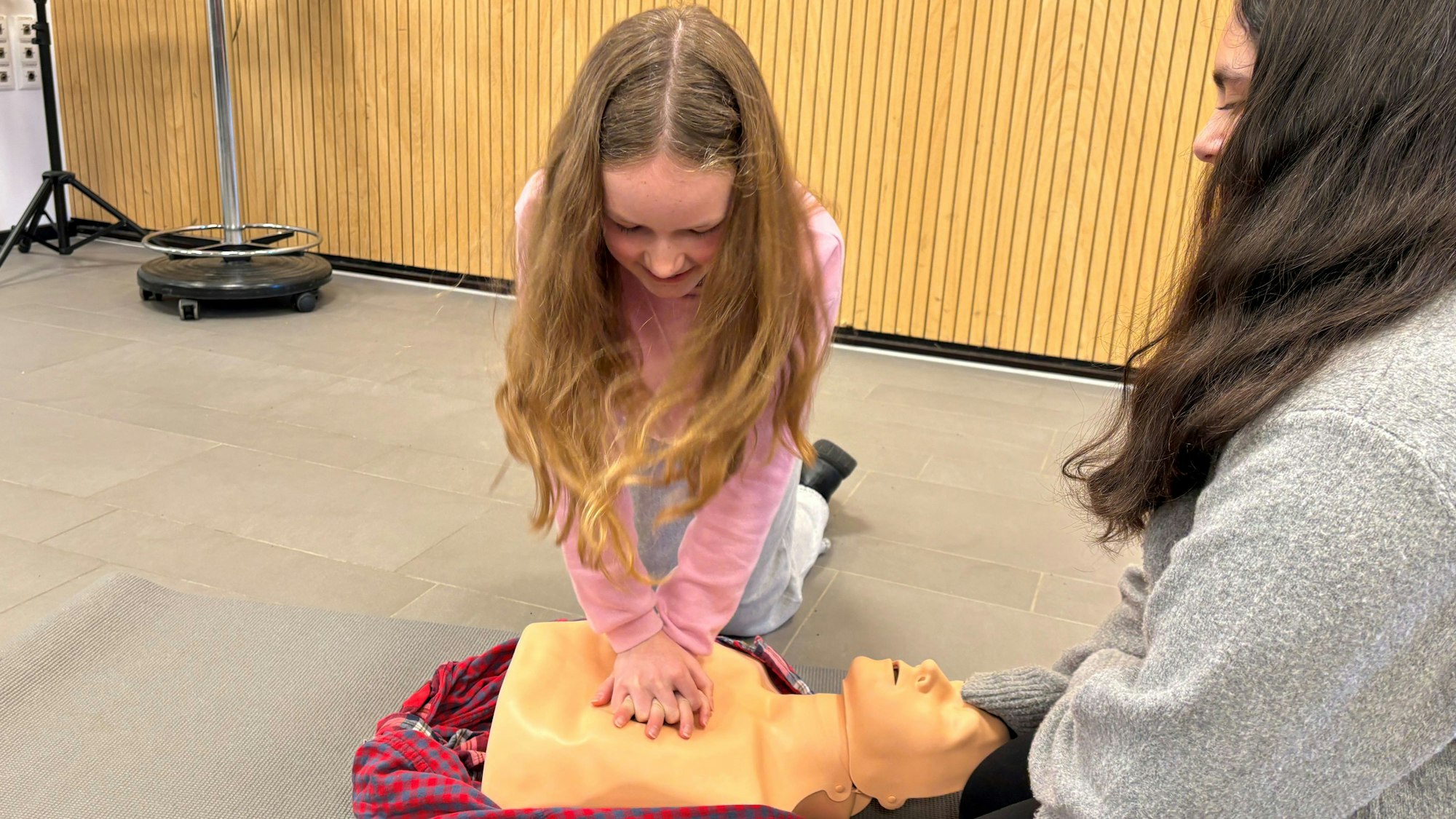 Leen und Carolin (l.) gehören zum Schulsanitätsteam des Gymnasium Alfter und zeigen, wie Herzdruckmassage funktioniert.