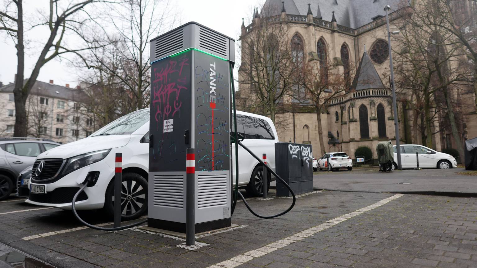 Ein Elektroauto steht an einer Ladesäule im Agnesviertel, die bereits mehrfach beschädigt wurde.