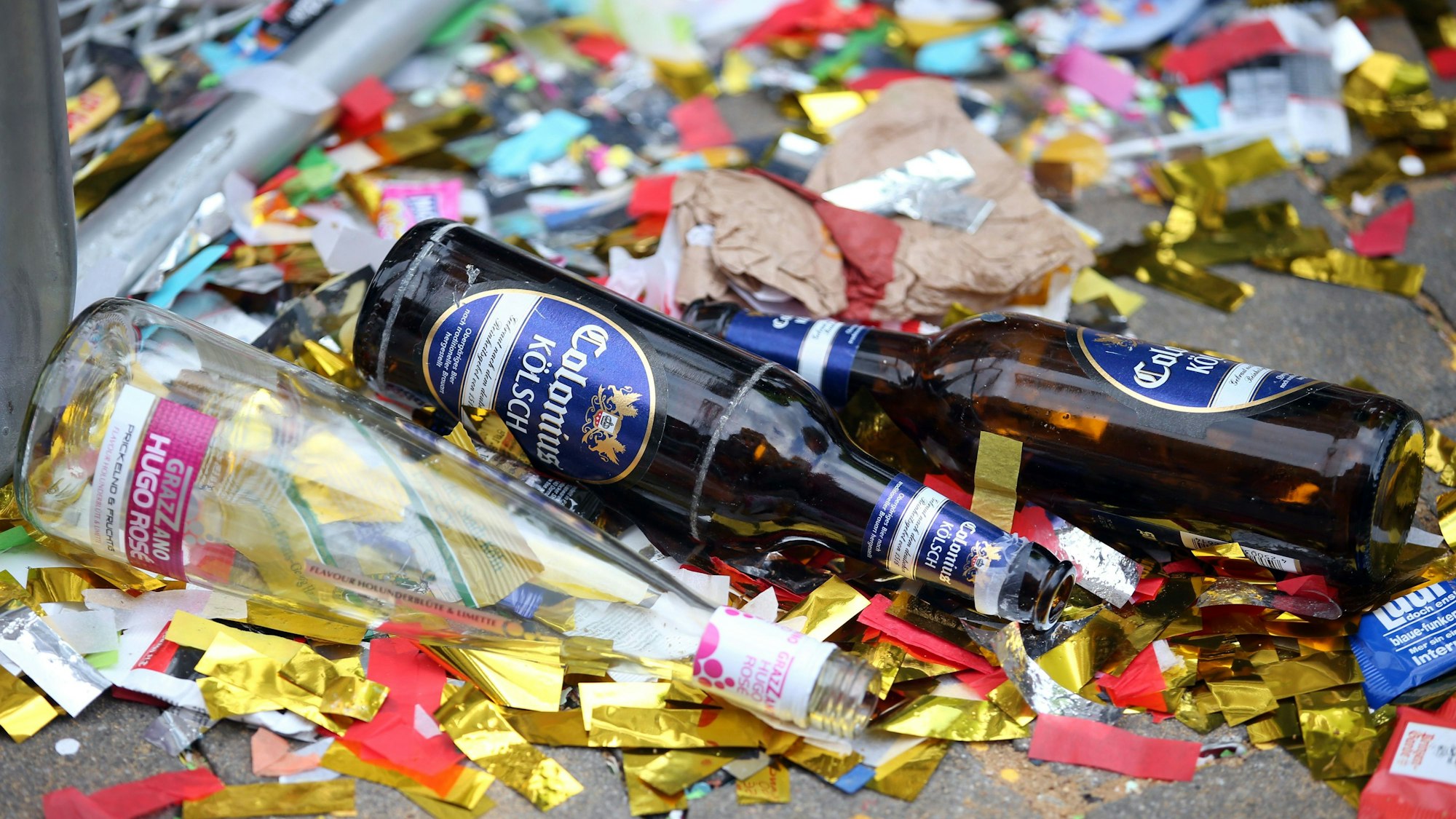 Leere Bierflaschen liegen nach dem Rosenmontagszug auf der Straße.