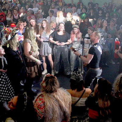 Die Karnevalsband Kuhl un de Gäng tritt mitten im verkleideten Publikum auf.