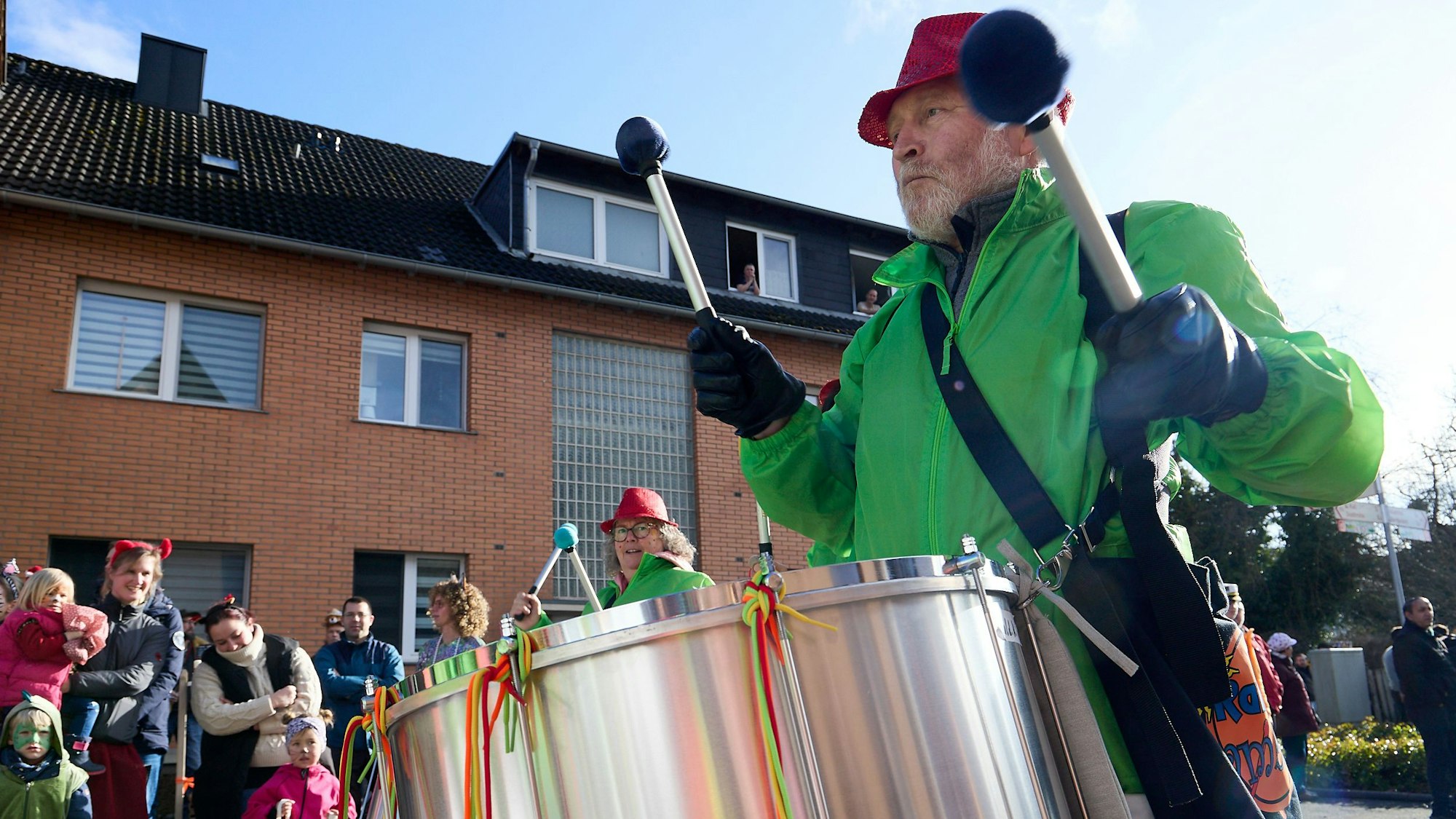 Ein Trommler der Gruppe Ramba Samba Eifel hält seine Stöcke vorm Anschlagen der Trommel in die Luft.