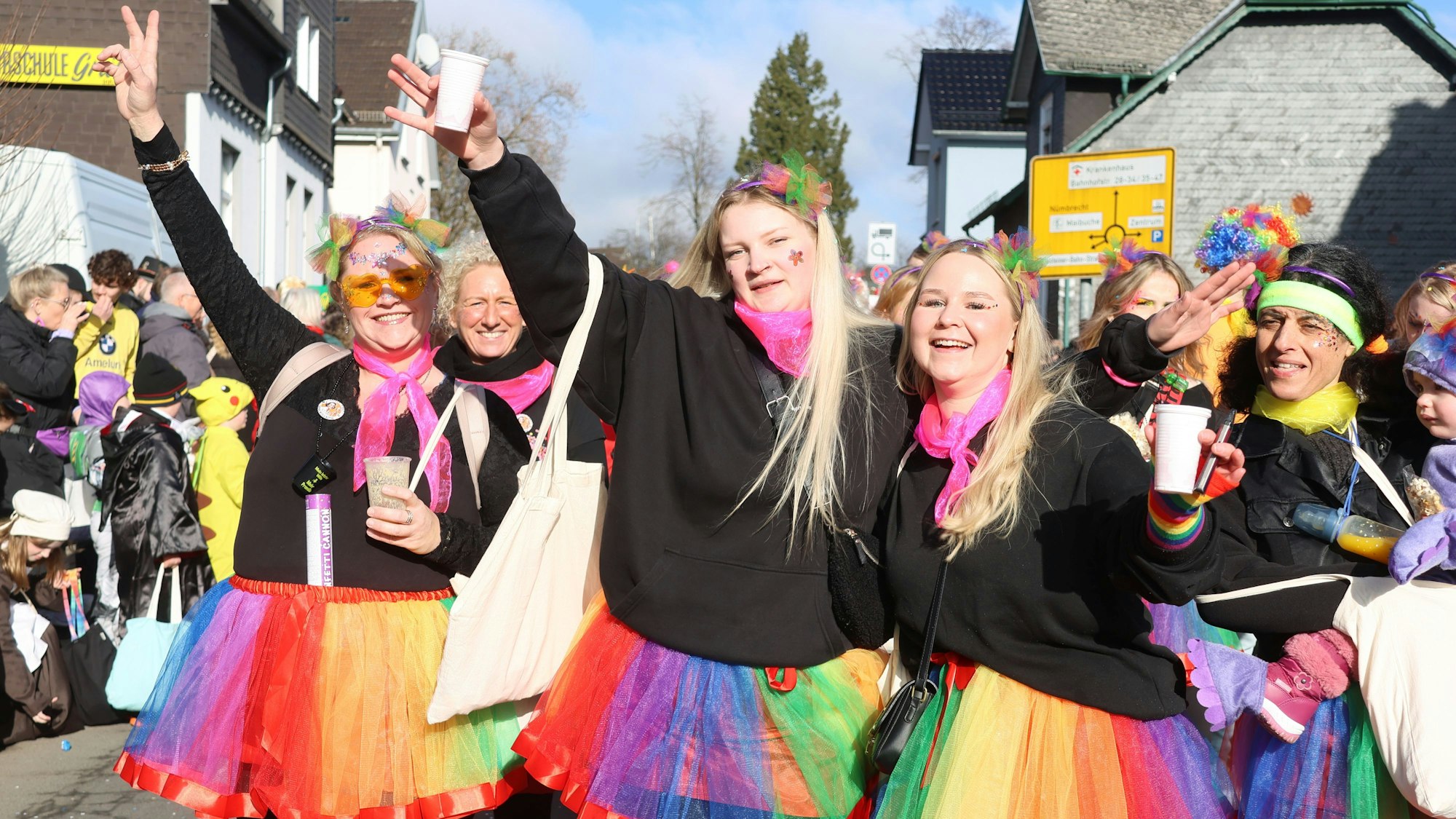 Frauen tragen bei einem Karnevalszug bunte Röcke.