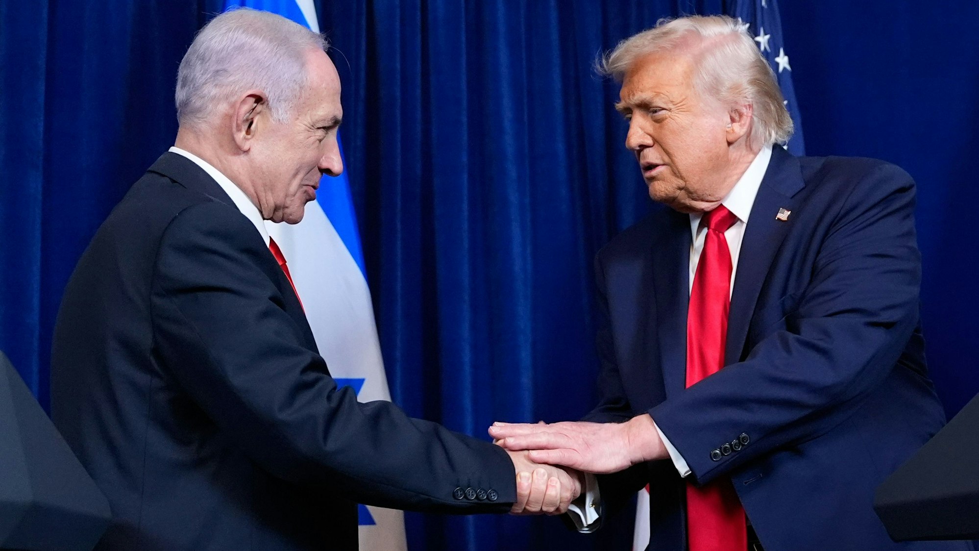 ARCHIV - 29.12.2025, USA, Palm Beach: US-Präsident Donald Trump (r) gibt dem israelischen Ministerpräsidenten Benjamin Netanjahu während einer gemeinsamen Pressekonferenz in Mar-a-Lago die Hand. (zu dpa: «Netanjahu pocht auf harte Linie bei Iran-Gesprächen») Foto: Alex Brandon/AP/dpa +++ dpa-Bildfunk +++