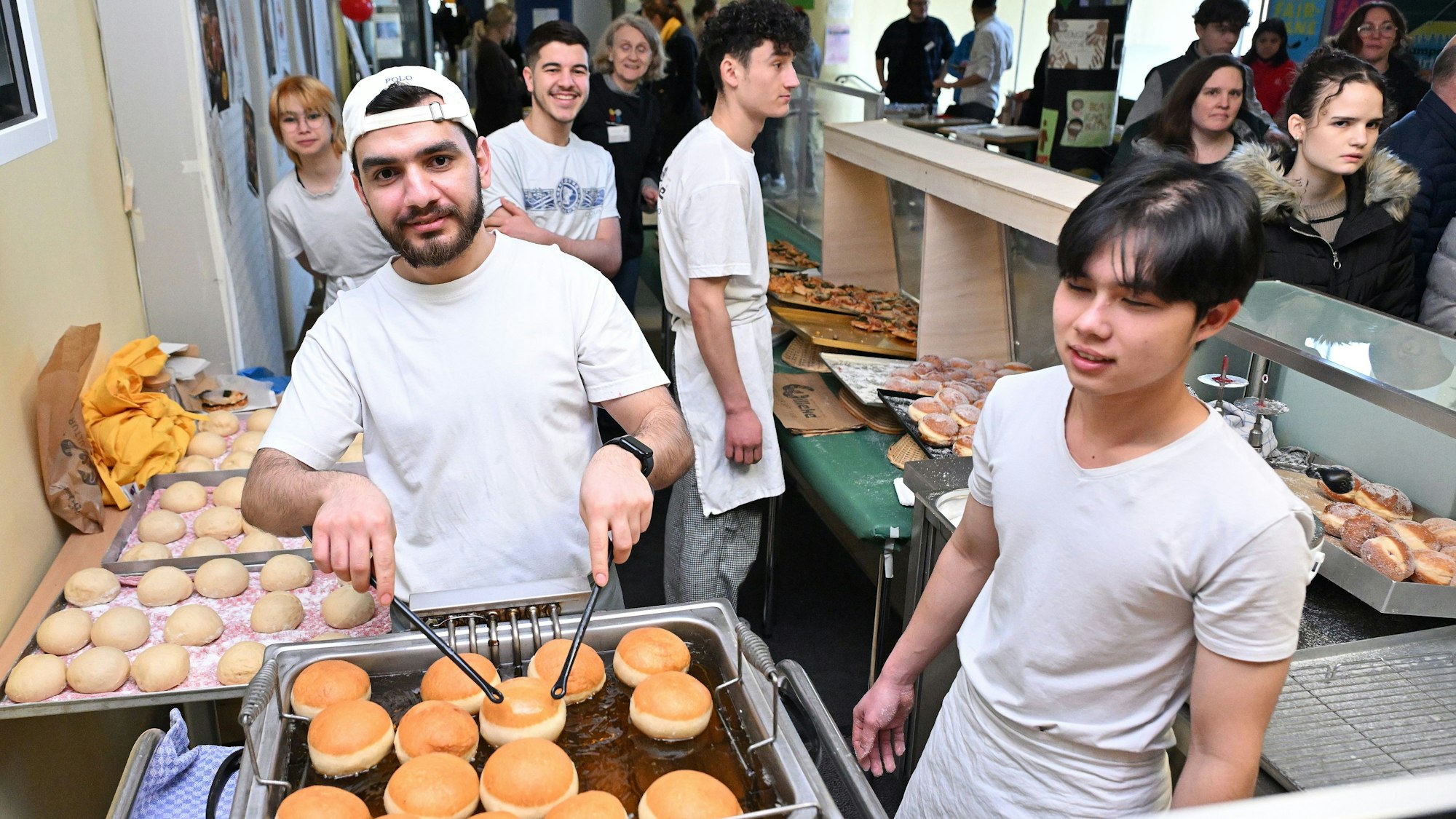Ein Bäcker backt Berliner.