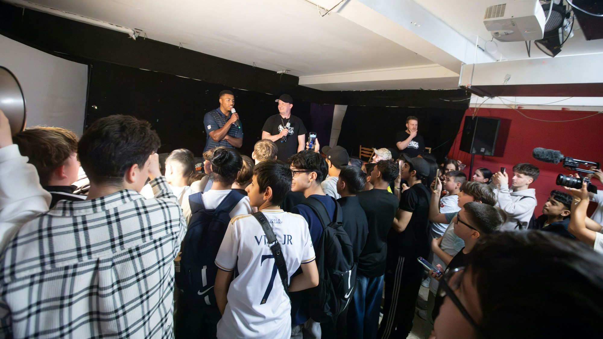 Auf der Bühne im Jugendzentrum in Porz steht NFL-Star Marcus Jones.