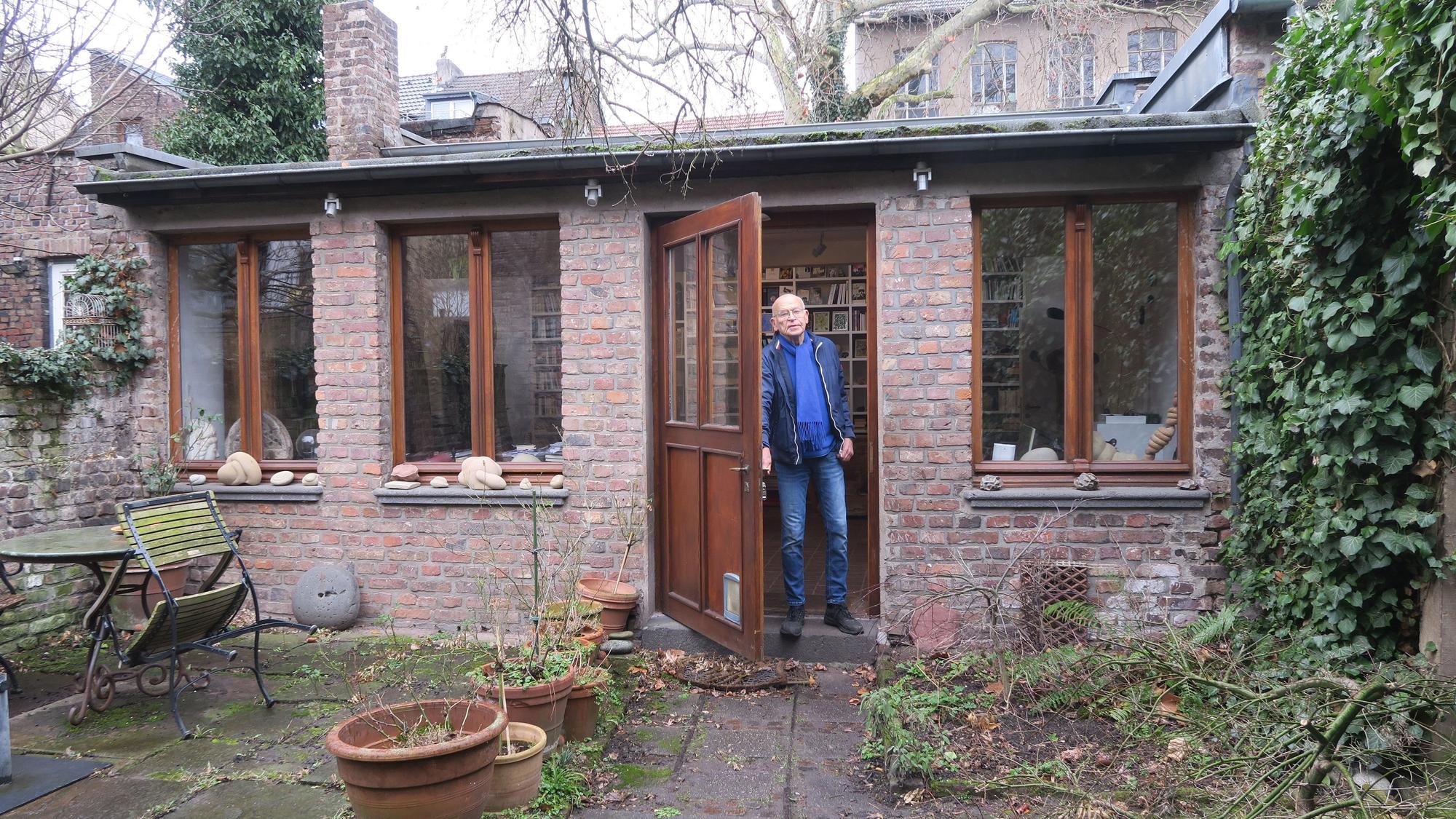 Wallraff vor dem Anbau im hinteren Bereich seines Gartens, im Hintergrund ist die Rückfront des Allerweltshauses zu sehen.