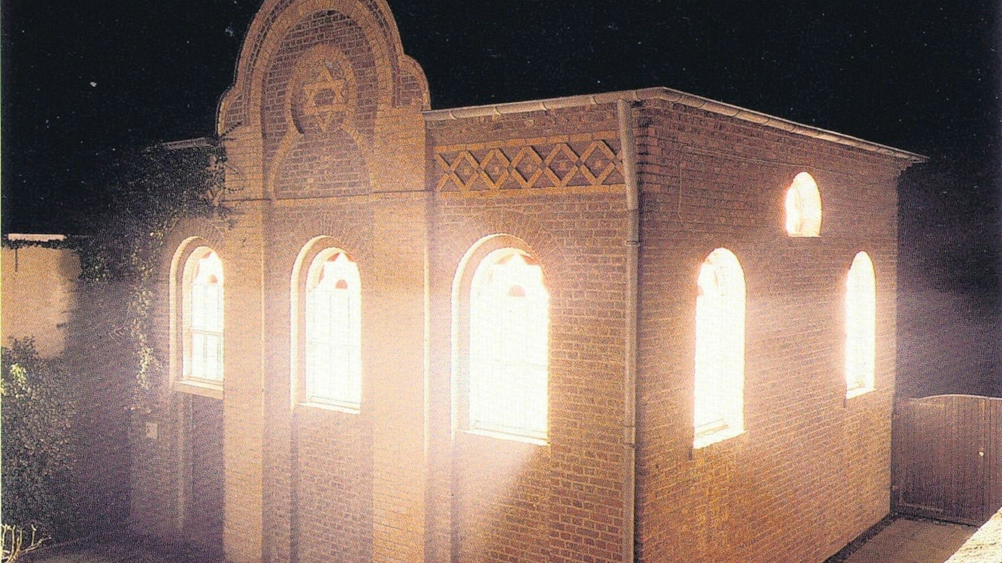 Zu sehen ist eine hell erleuchtete Synagoge.