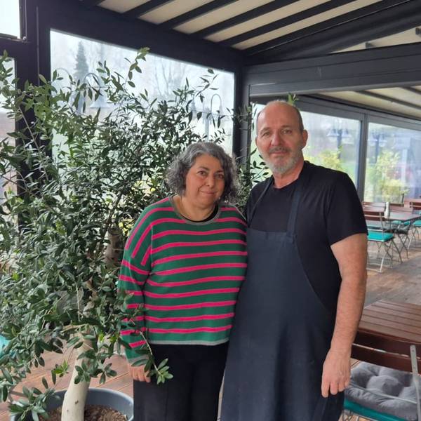 Eine Frau und ein Mann stehen im Wintergarten eines Restaurants.