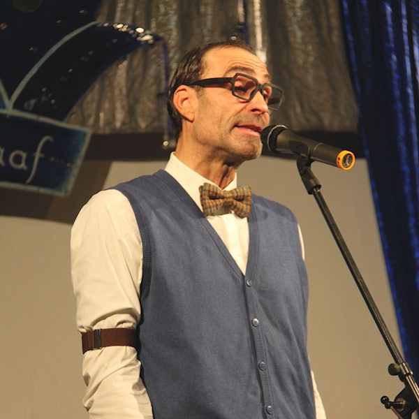 Das Bild zeigt den Obengenannten auf der Bühne in Blankenheimerdorf. Er steht an einem Mikrofon.