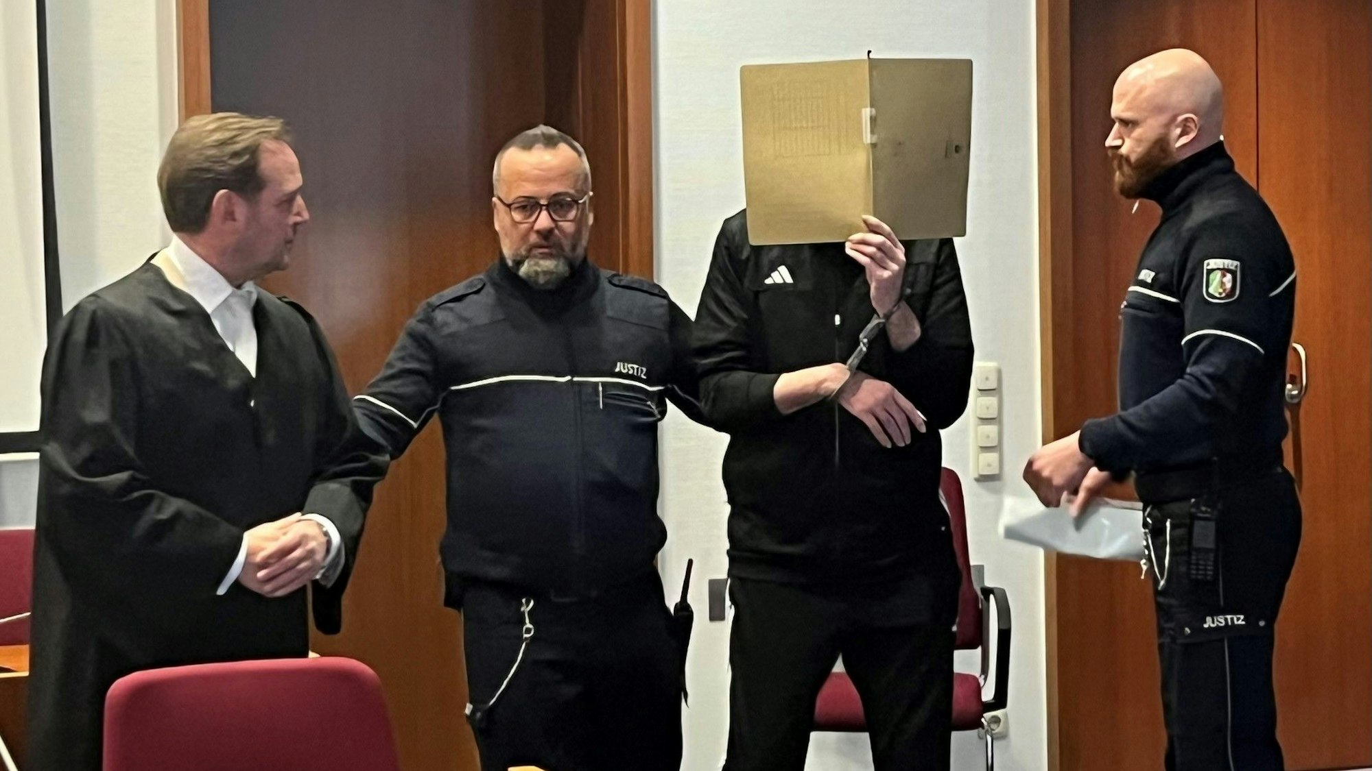 Der Angeklagte verbarg sein Gesicht hinter einer Aktenmappe.