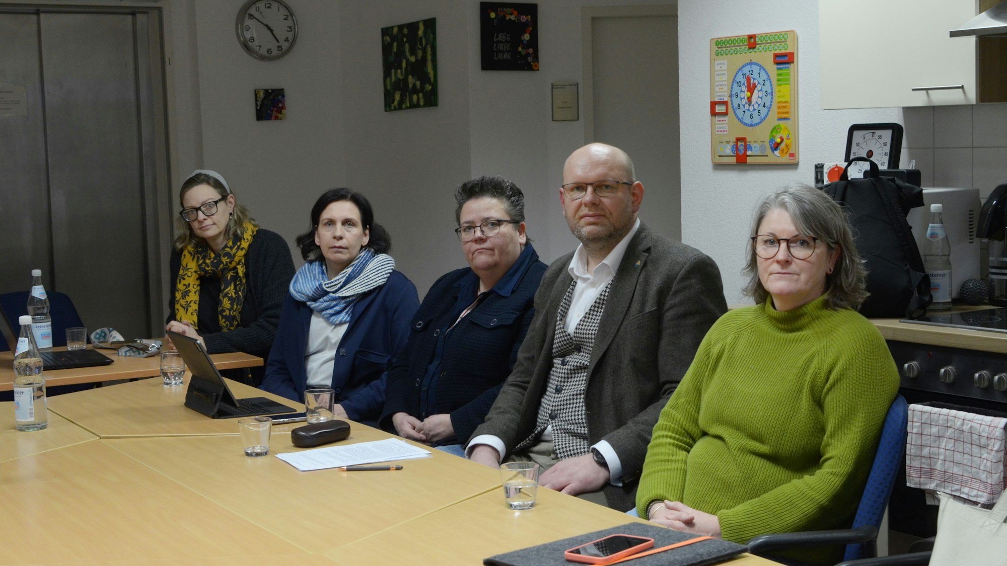 Tobias Köhler und vier Frauen sitzen in einer Reihe an einem Tisch.