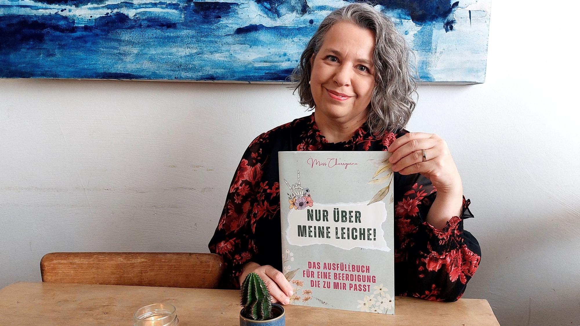 Die Künstlerin Tina Damm alias „Miss Cherrywine“ hat ein Vorsorgebuch für die eigene Beerdigung geschaffen.