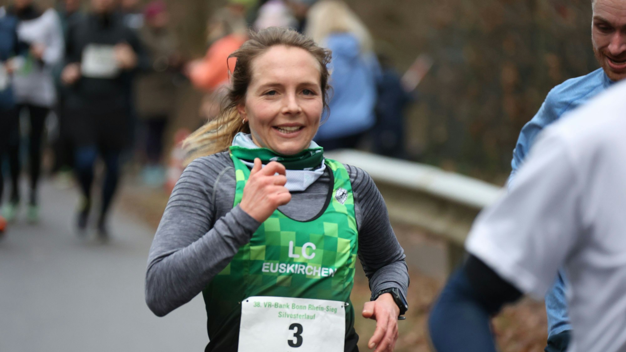 Hinter und neben der Läuferin sind weitere Teilnehmer auf der Strecke unterwegs.