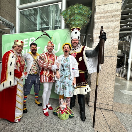 Das Dreigestirn aus Rodenkirchen steht mit zwei Klinik-Clowns im Foyer der Uniklinik.