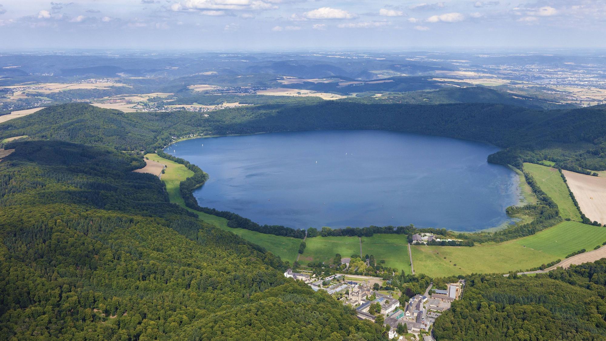 Luftbild vom Laacher See in der Eifel. Im Vordergrund ist die Abtei Maria Laach zu sehen.
