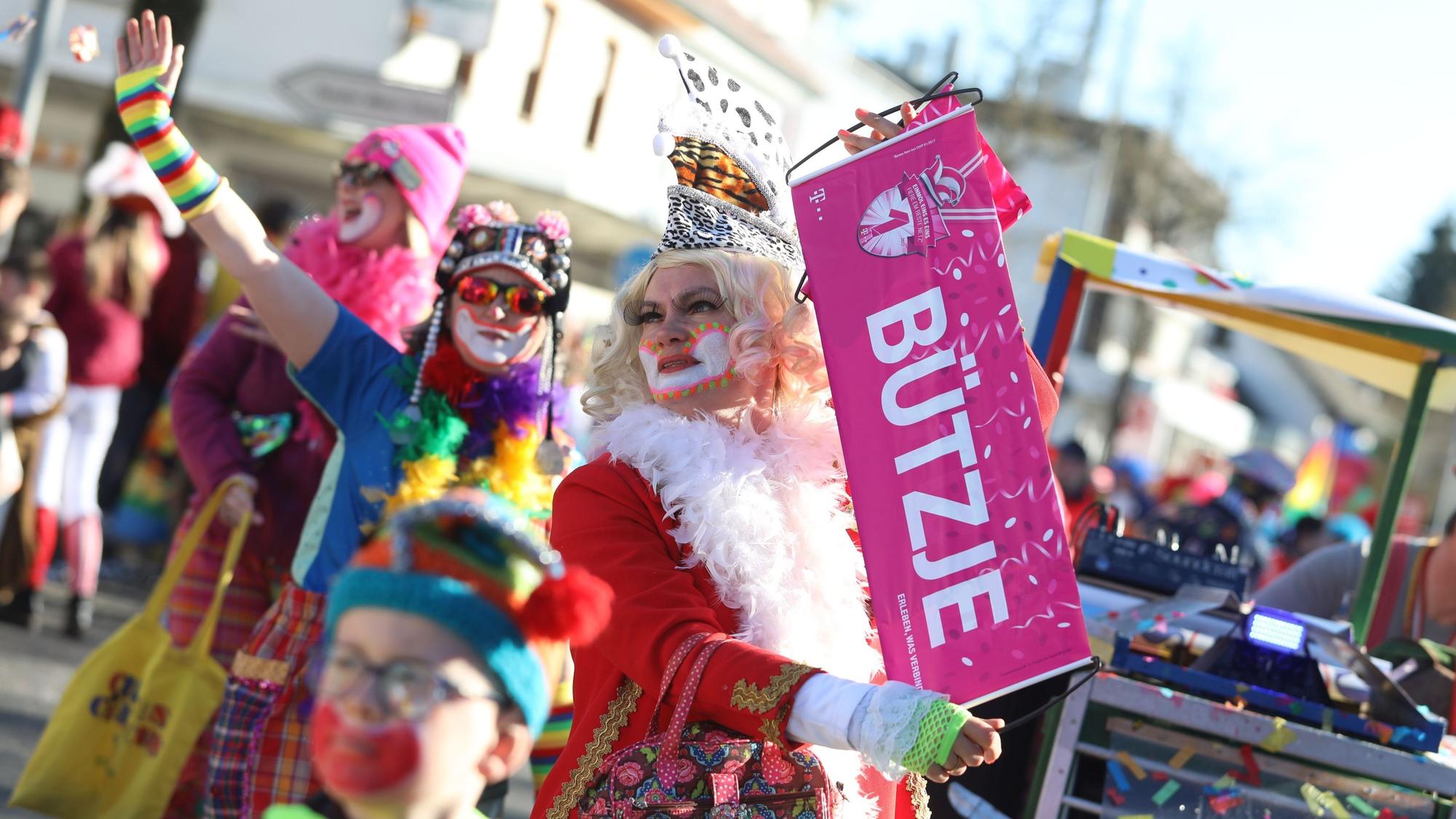 Eine Zugteilnehmerin hält ein Banner mit dem Wort „Bützje“ in der Hand.