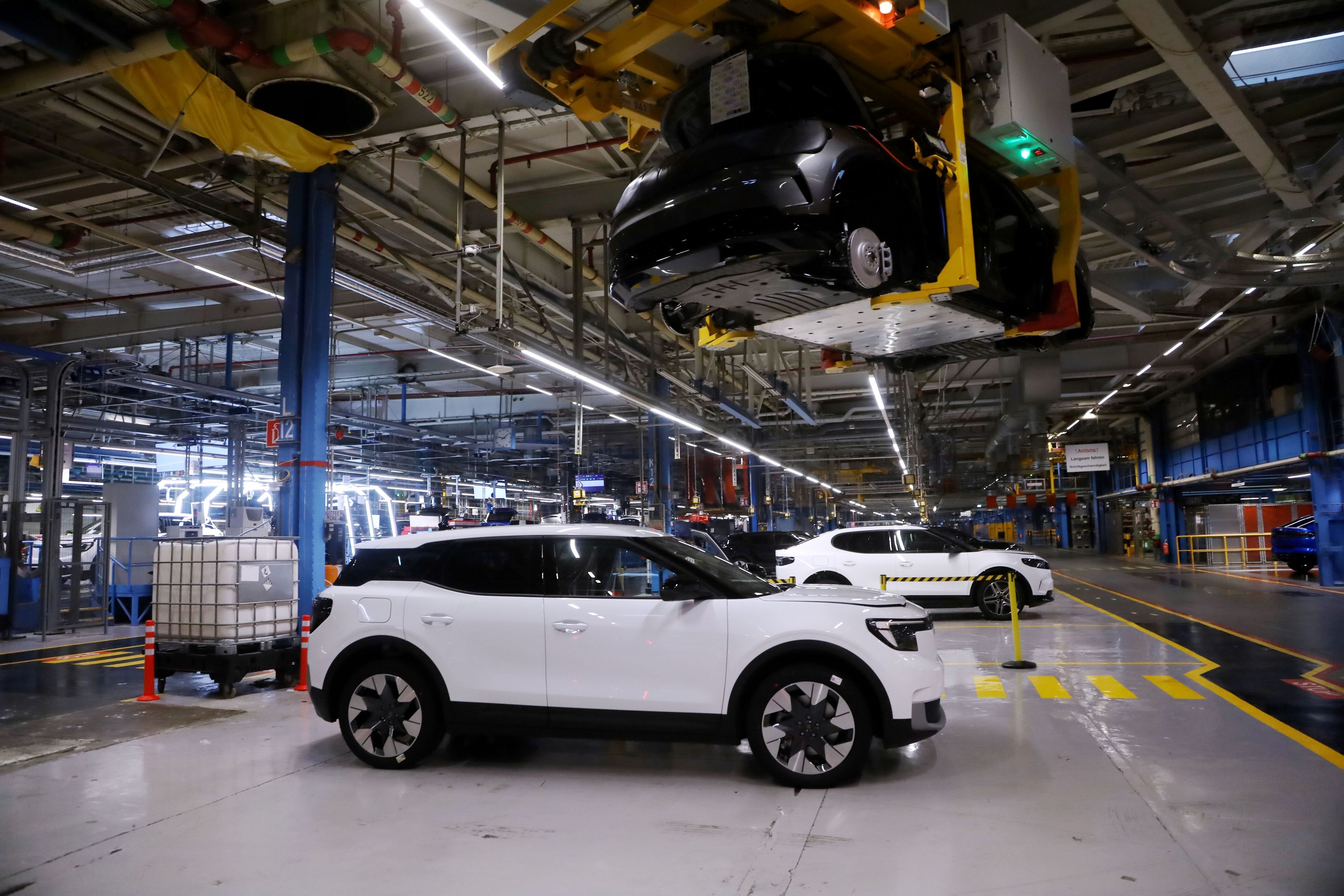 Ein weißer Ford Explorer kurz vor der Abnahme in den Fordwerken in Niehl. Im Hintergrund ein ebenfalls elektrischer Ford Capri