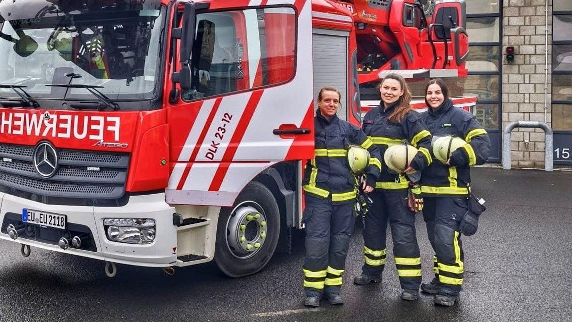 Das Bild zeigt die drei Feuerwehrfrauen vor einem Feuerwehrfahrzeug.