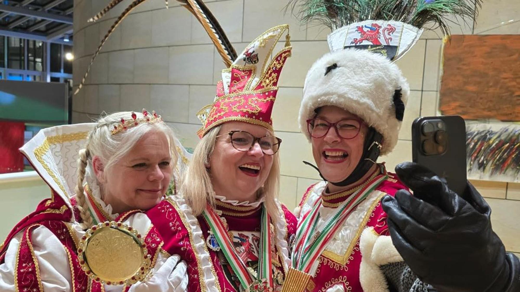 Das Lindlarer Damen-Dreigestirn
macht ein Selfie mit einem Handy.