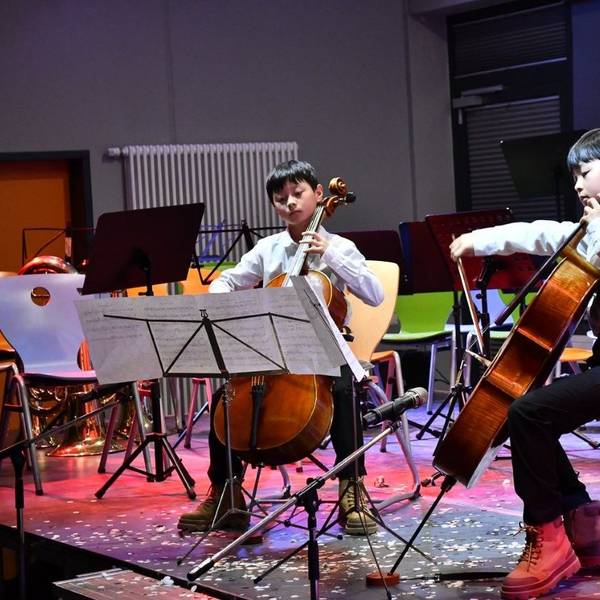 Zwei Jungs spielen Cello.