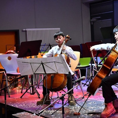 Zwei Jungs spielen Cello.