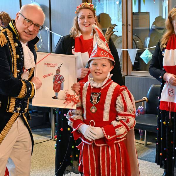 Heimbachs Bürgermeister Jochen Weiler ist kostümiert und zeigt Kinderprinz Linus sein Bild für die Tollitätengalerie.