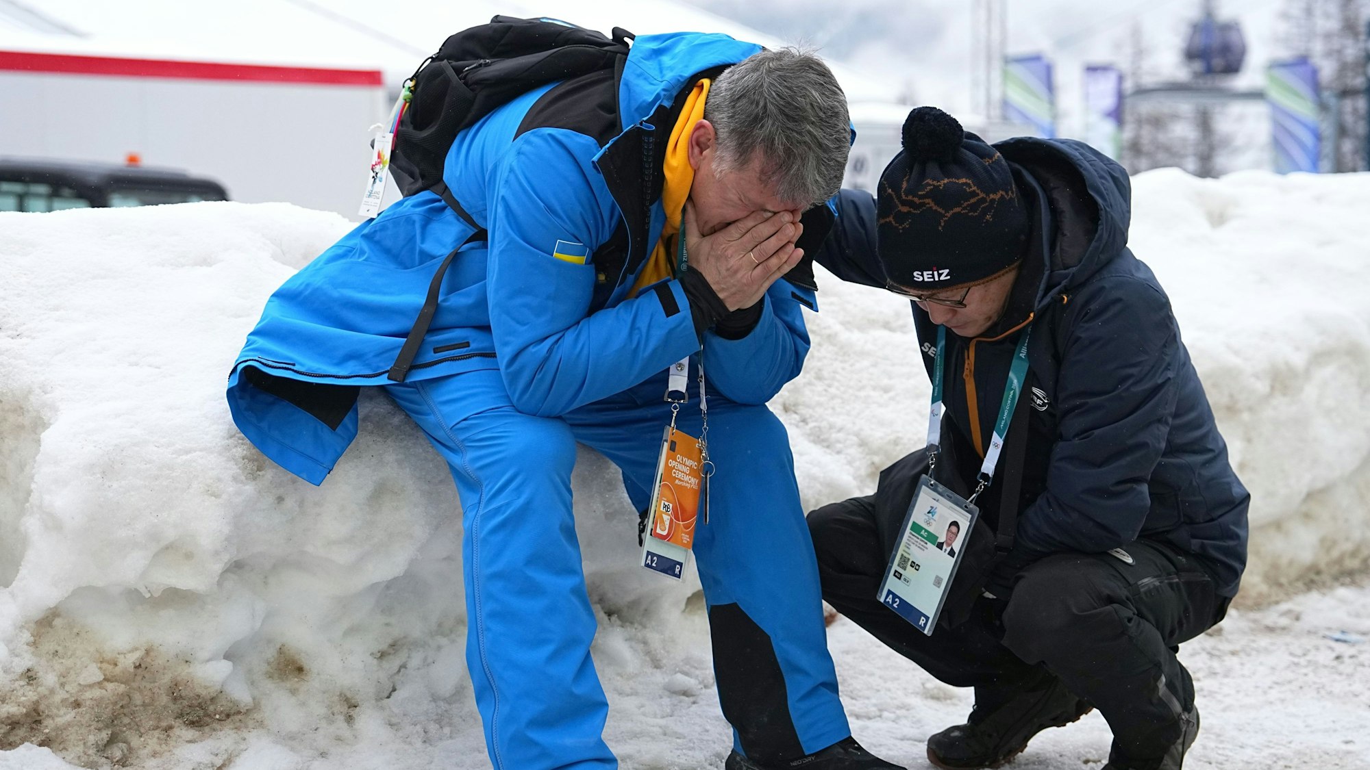 Mychajlo Heraskewytsch (l.), Vater des ukrainischen Skeleton-Athleten Wladislaw Heraskewytsch reagiert emotional und hält sich die Hände vor das Gesicht.