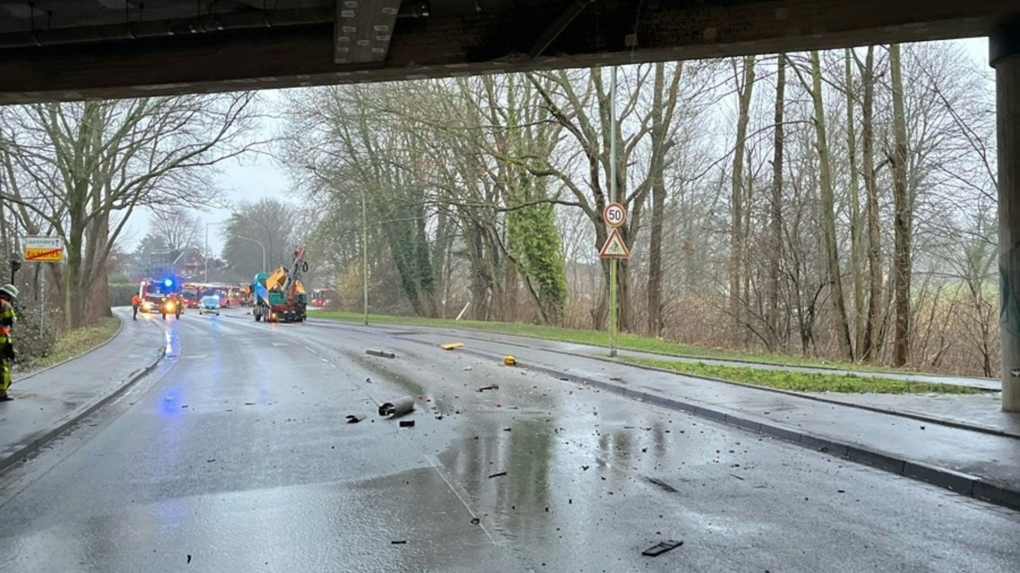 Trümmerteile liegen auf einer Straße. Ein Lkw ist mit seinem Kranarm gegen die Decke einer Unterführung der A4 bei Aachen gestoßen.