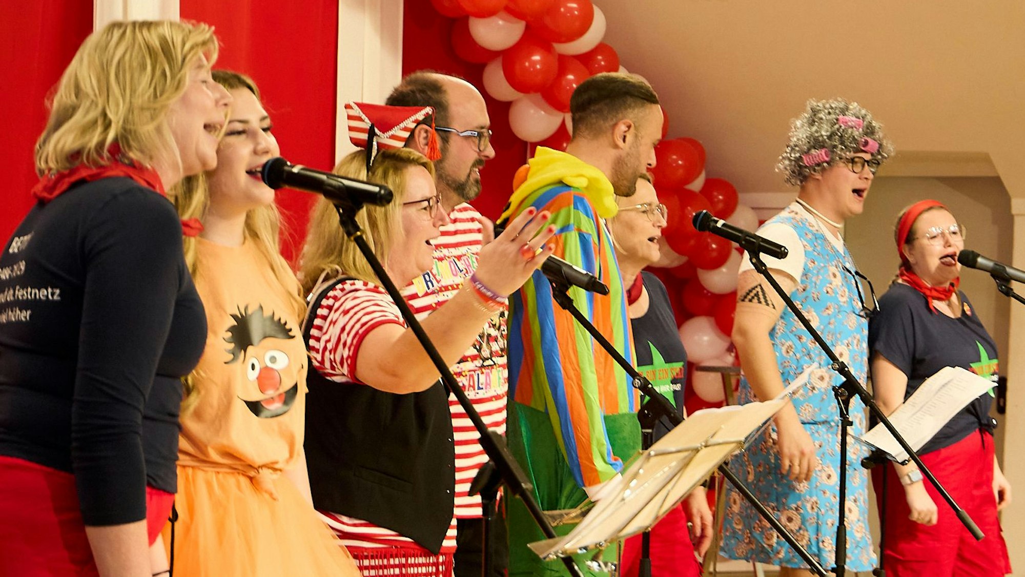 Mitarbeiter der Gemeindeverwaltung Nettersheim tragen Karnevalskostüme und singen auf der Bühne im Dorfsaal Zingsheim.